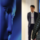 A woman walks by a screen with a fake digital face staring back at her.